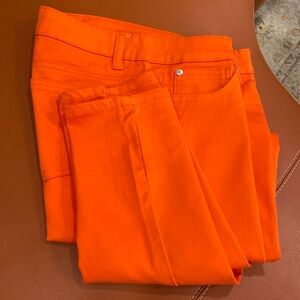 Bright orange skinny pants.